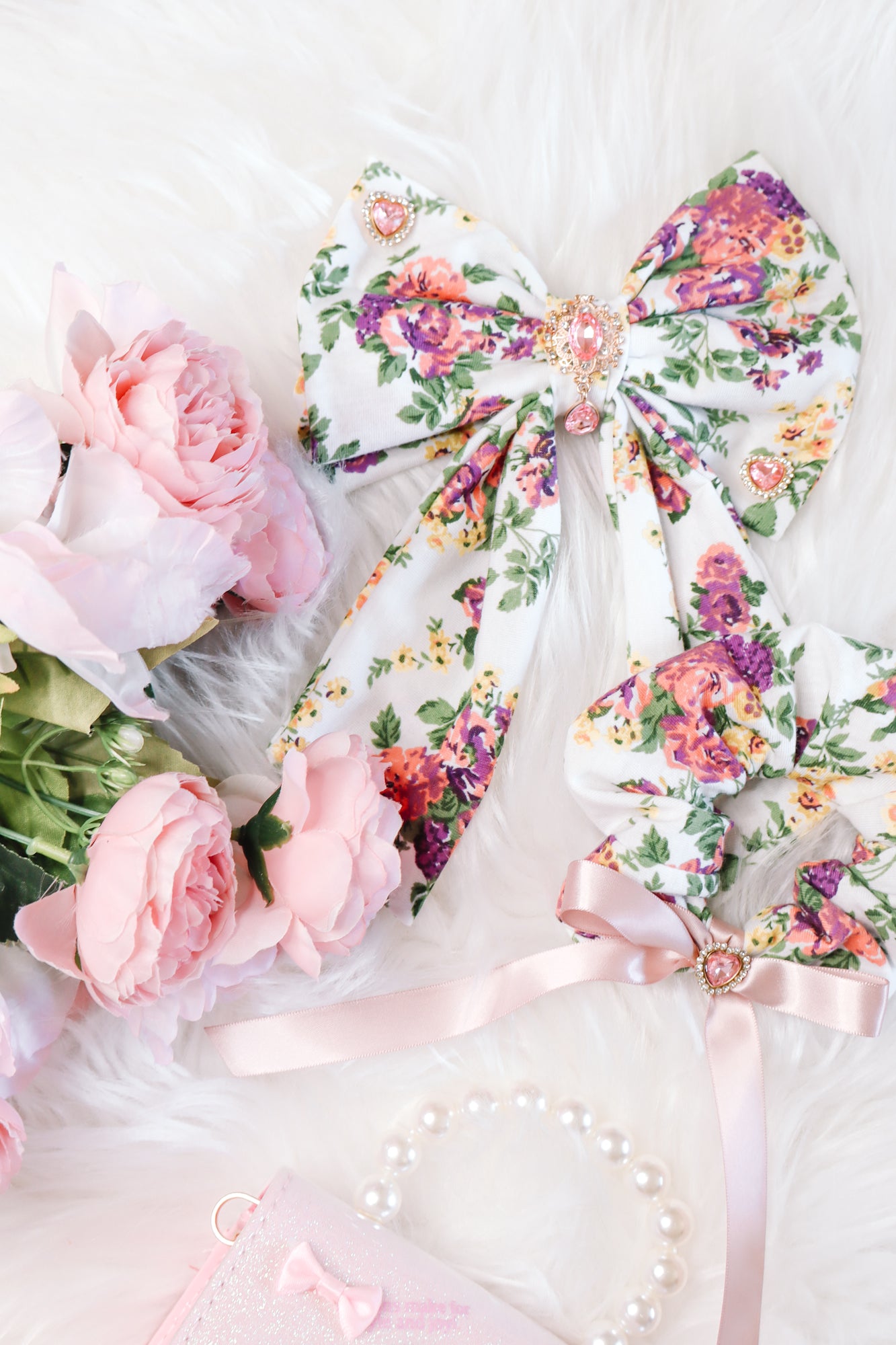 White floral bow and white floral scrunchie flatlay